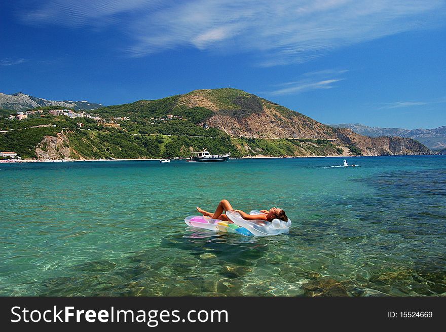 A girl sunbathing on a mattress in Adriatic waters in Montenegro