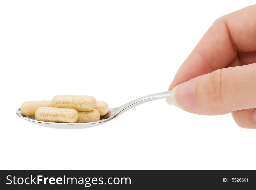 Pills in a spoon isolated on white background