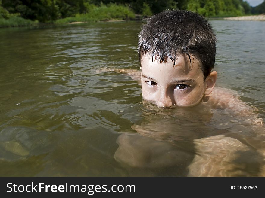 A young boy plays in a clear creek. A young boy plays in a clear creek.