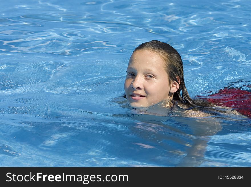 Young long haired girl swimming in bright blue water. Young long haired girl swimming in bright blue water