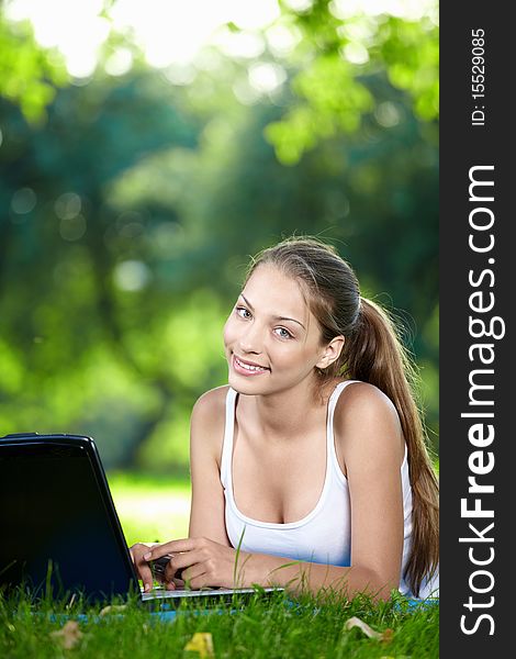 Young girl with laptop in the park