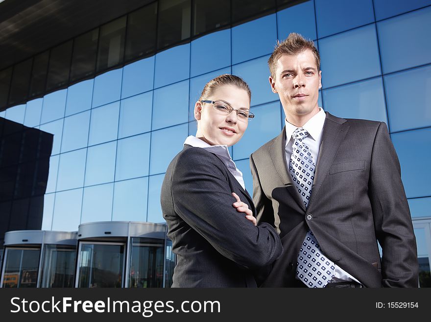 Two business people in suits against the business building. Two business people in suits against the business building