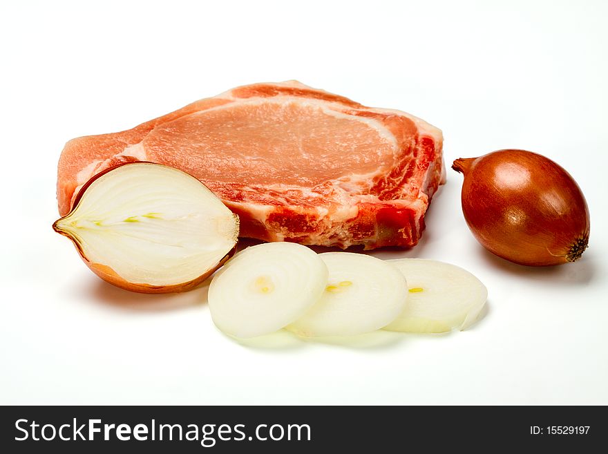 Pork stake and the cut onions isolated on a white background. Pork stake and the cut onions isolated on a white background
