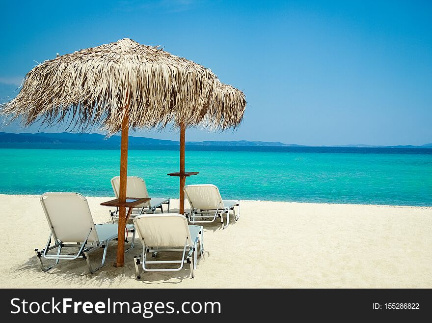 A beautiful beach chairs near the seashore of Greece on the nature background