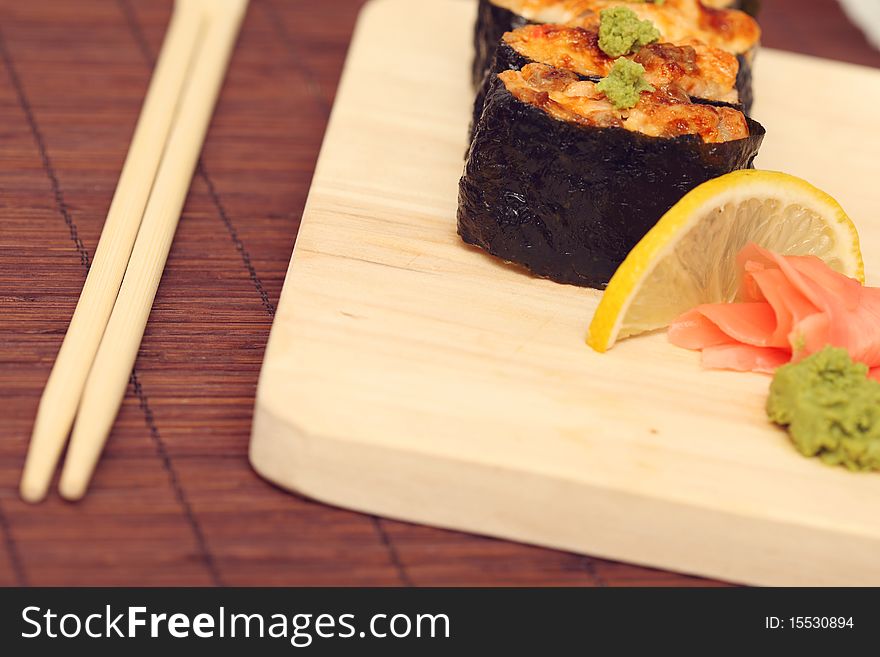 Sushi and rolls on the wooden plate close-up