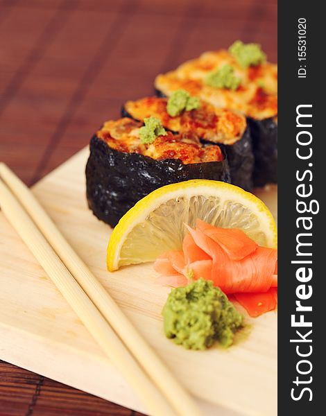 Sushi and rolls on the wooden plate close-up