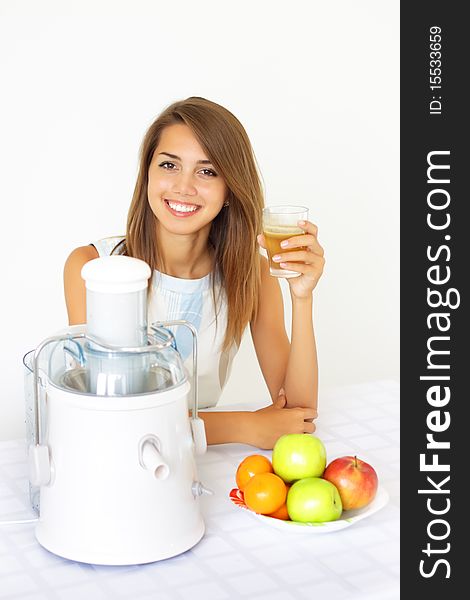 Happy girl about juicers on a light background