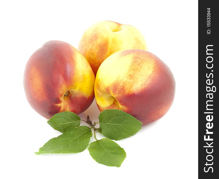 Peaches with green leaves on a white background