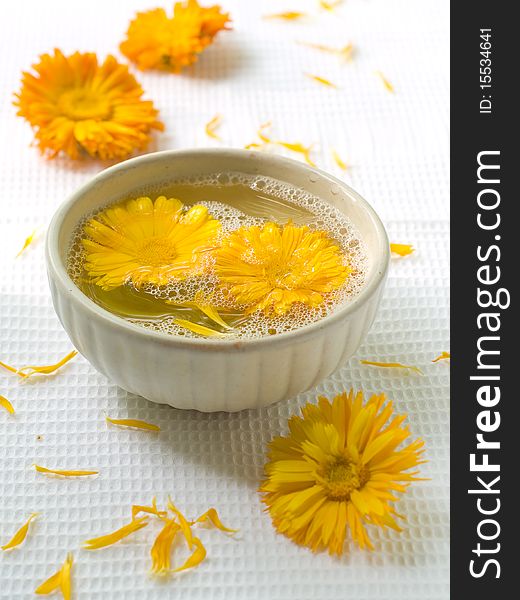 Bowl of water and flowers . Chamomile on background. Could be a generic toiletry.