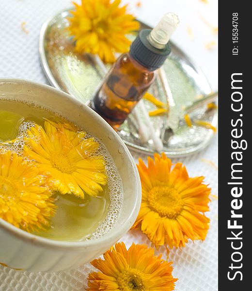 Bowl of water with yellow flower. Device for manicure on background. Could be a generic toiletry. Bowl of water with yellow flower. Device for manicure on background. Could be a generic toiletry.