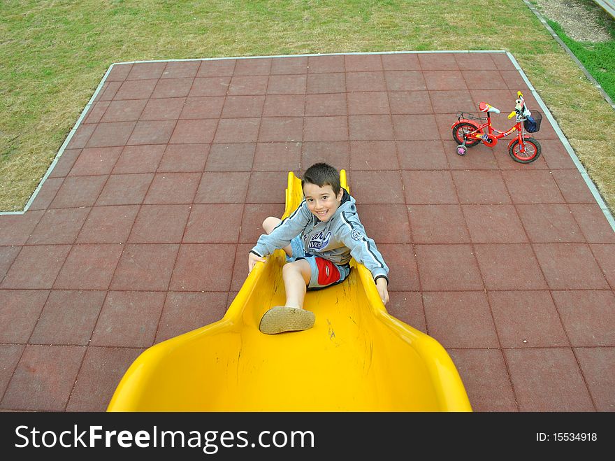 Boy sliding on the yellow slide. Boy sliding on the yellow slide
