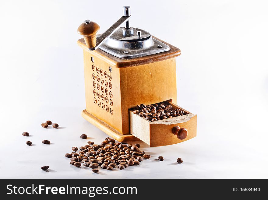 Antique yellow wooden coffee mill full of coffee seeds. Antique yellow wooden coffee mill full of coffee seeds