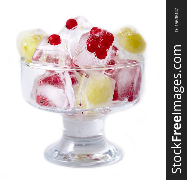 Berries in ice in a glass vase. Isolated, white background. Berries in ice in a glass vase. Isolated, white background