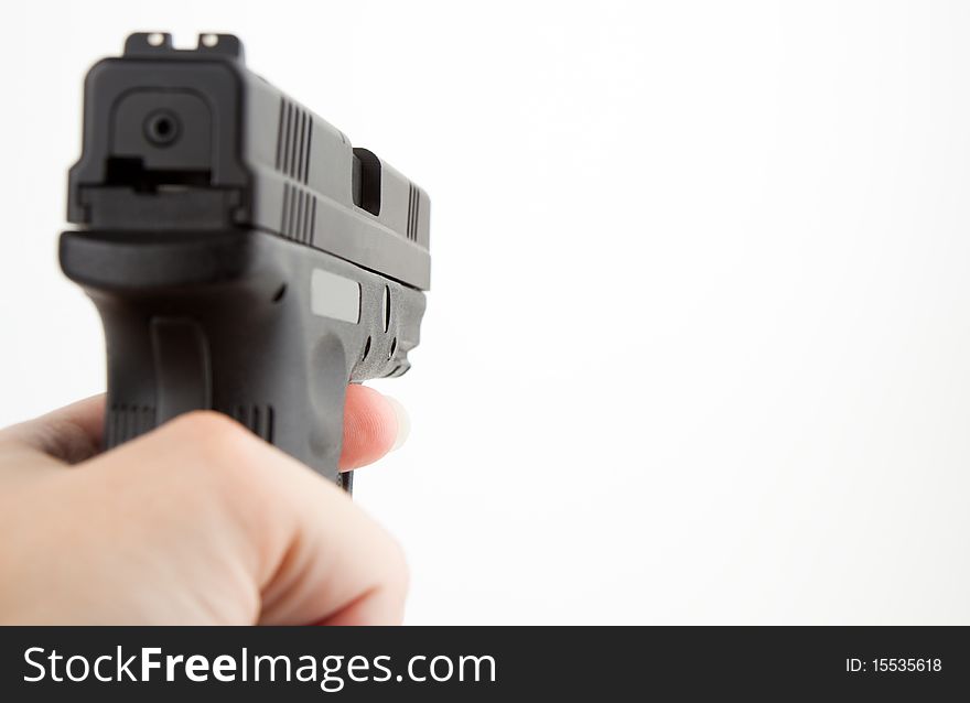 Female hand pointing gun toward white background. Female hand pointing gun toward white background