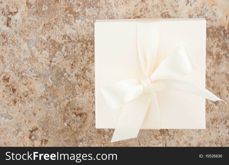 Cream colored favor box against variegated neutral background