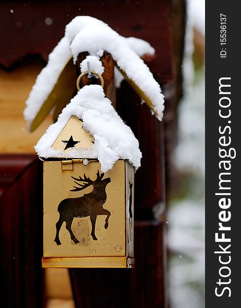 Snow cap on a  golden Christmas lantern with deer and stars