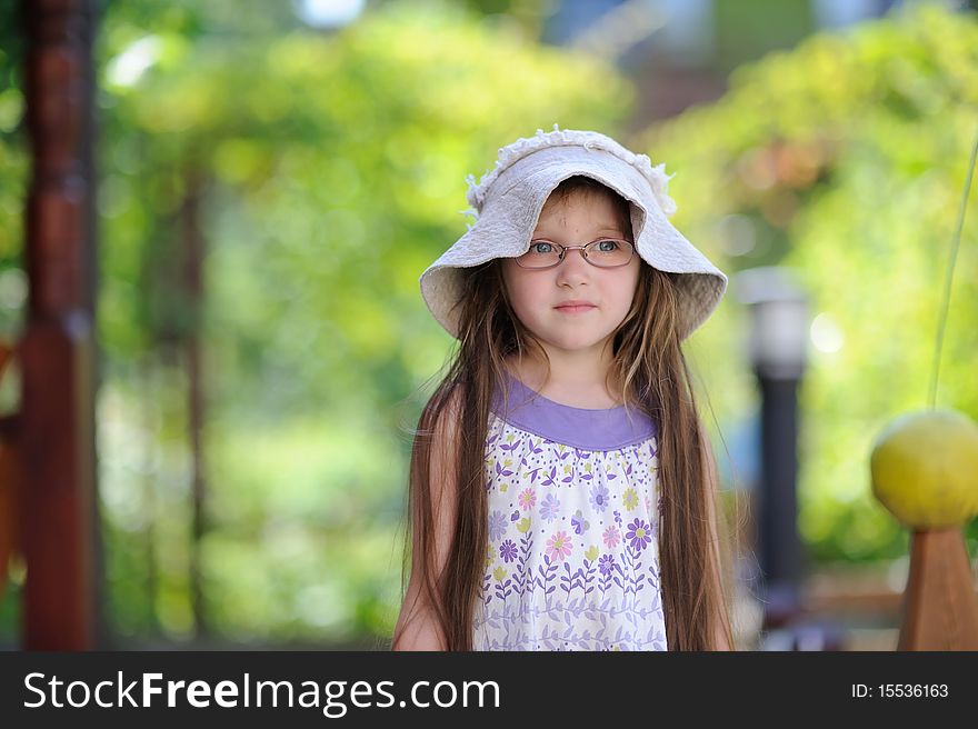 Toddler girl in sun hat on the green background