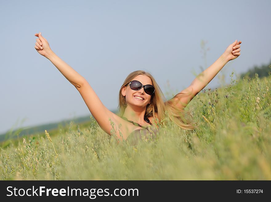 Young woman with glasses in the field happy and laughing.