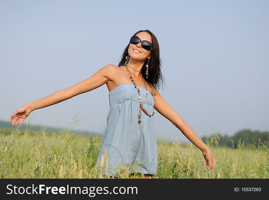 Young woman with glasses in the field happy and laughing.