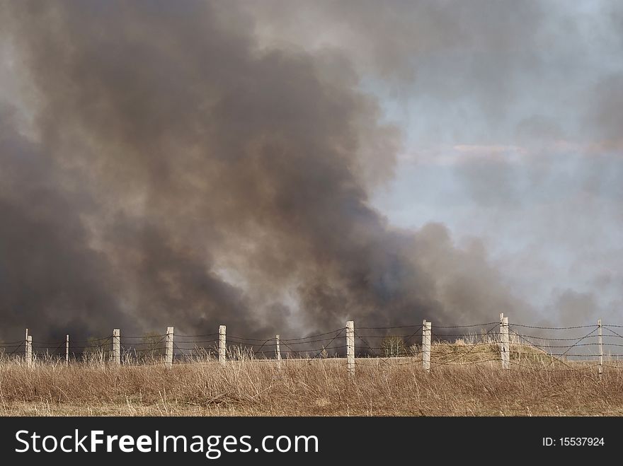 Thick smoke over a burning field