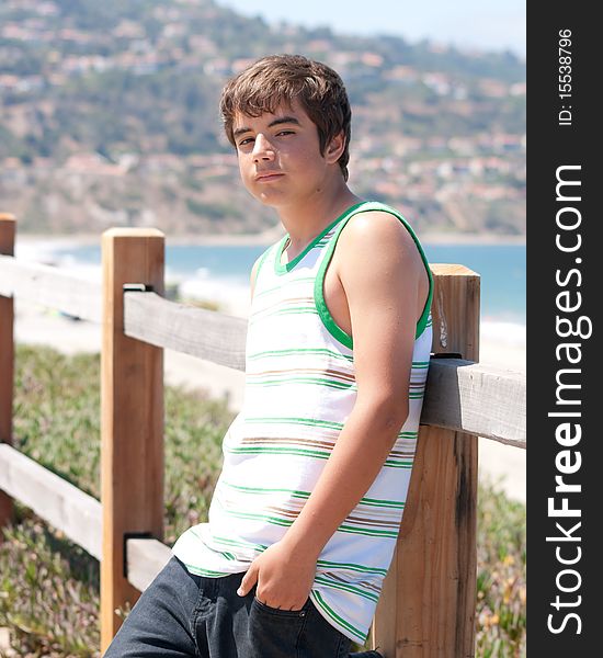 Young Teenage Boy Leaning on Fence Looking Tough. Young Teenage Boy Leaning on Fence Looking Tough
