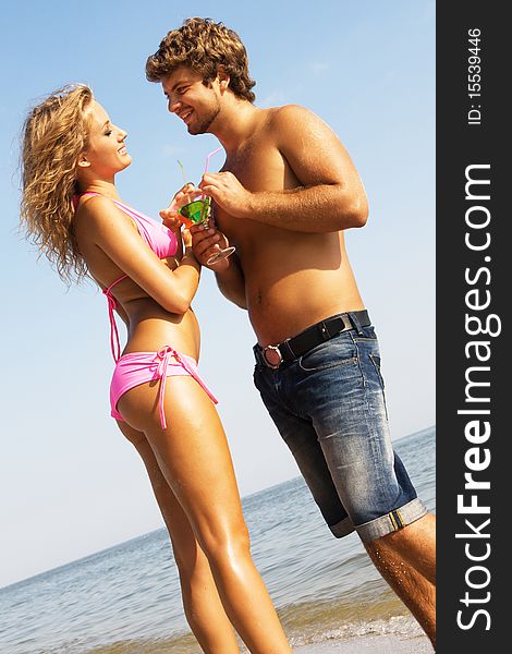 Young couple with cocktails on the seaside