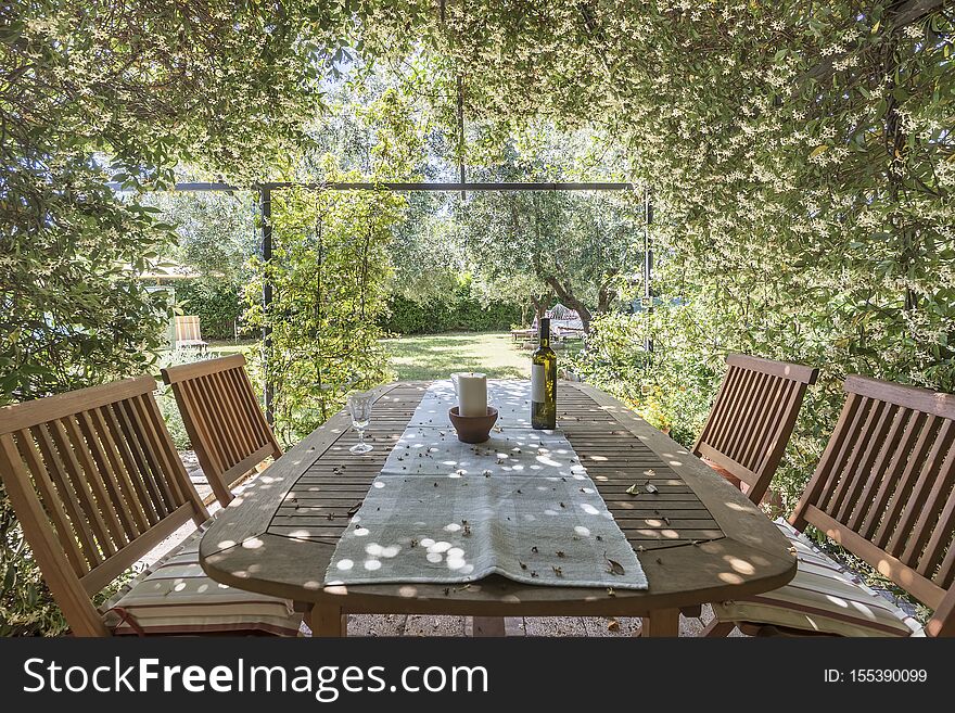 Garden table and chairs surrounded with jasmine flowers. Garden table and chairs surrounded with jasmine flowers