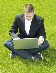 Young Businessman Sitting On Grass With Laptop Royalty Free Stock Photo