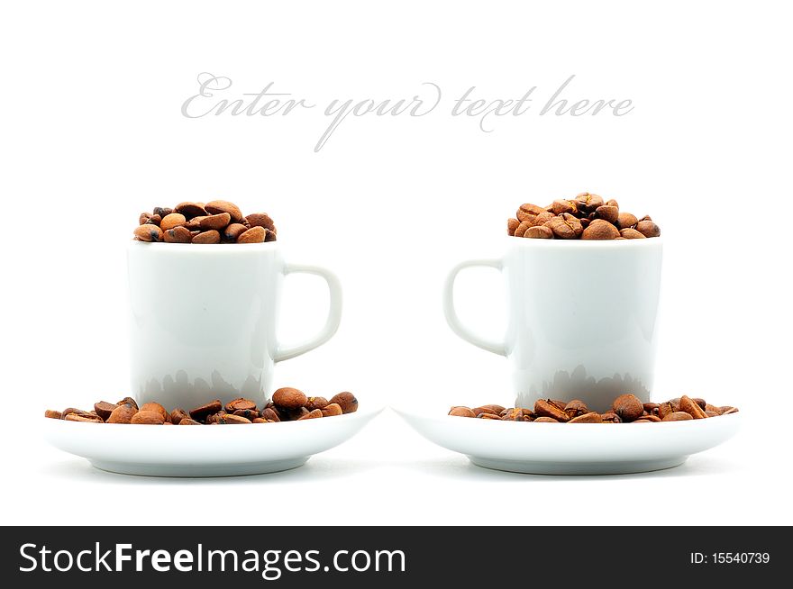 Two white cups on plates filled with coffee beans