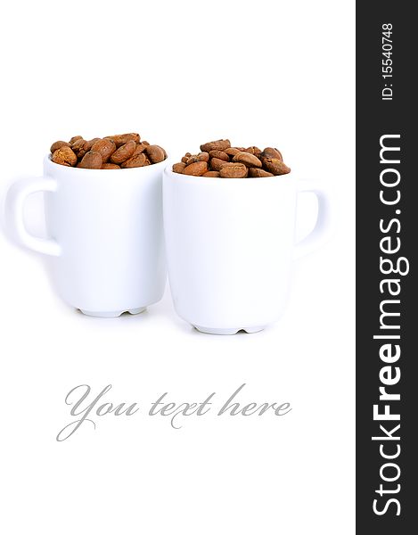 Couple of cups filled with roasted coffee beans. Couple of cups filled with roasted coffee beans