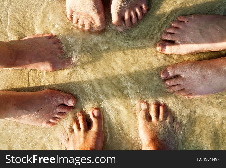 Feet Of A Family In The Fine Sand Of The Beach