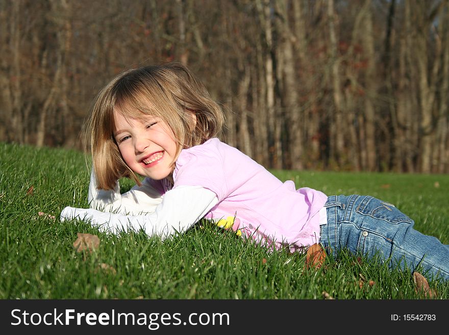 Little girl lying on her tummy in grass. Little girl lying on her tummy in grass