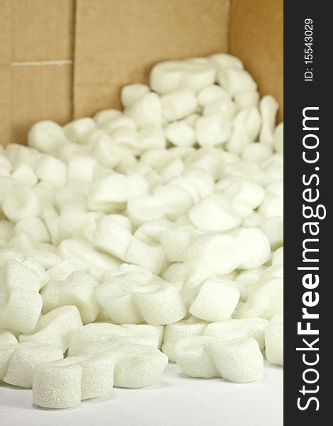 A closeup of packing peanuts spilling out of a cardboard box. A closeup of packing peanuts spilling out of a cardboard box