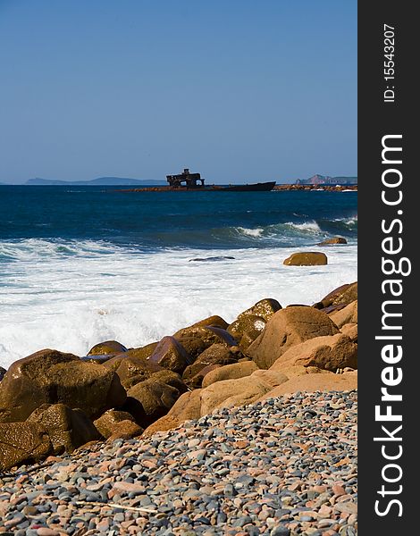 Old rusty broken ship on rocks beach