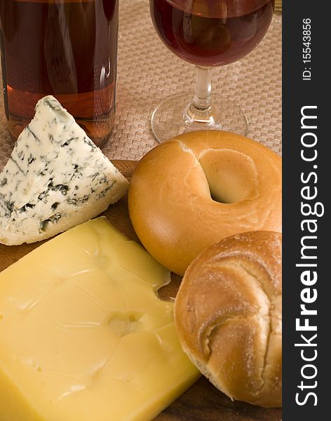 Bottle of wine with  bagels, and cheese on a cheeseboard. Bottle of wine with  bagels, and cheese on a cheeseboard