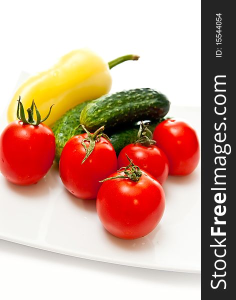 Tomato, cucumber and pepper in plate on white background. Tomato, cucumber and pepper in plate on white background