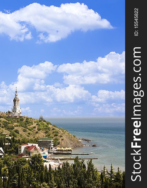 Photo of a crimea coastline with a church on a mountain in malorechenskoe