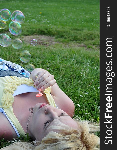 Girl Blowing Bubbles In Grass