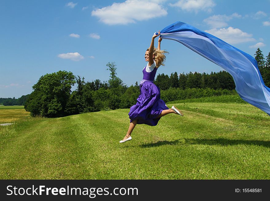 A bavarian girl jumping and waving flags