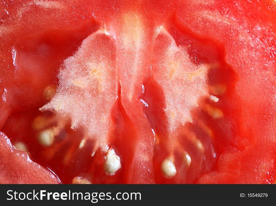 Sliced tomato extreme closeup red background. Sliced tomato extreme closeup red background