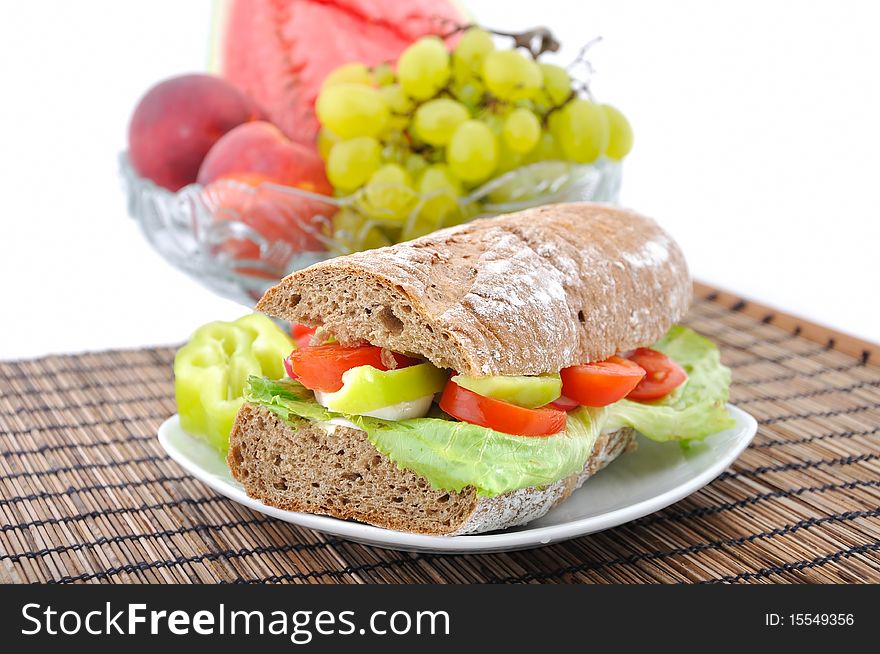 Diet brown baguette with vegetable and bow of fruits on background