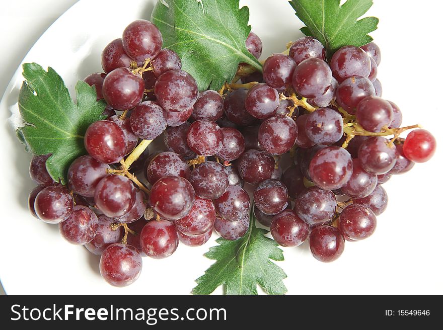 Close up red grape on white plate. Close up red grape on white plate