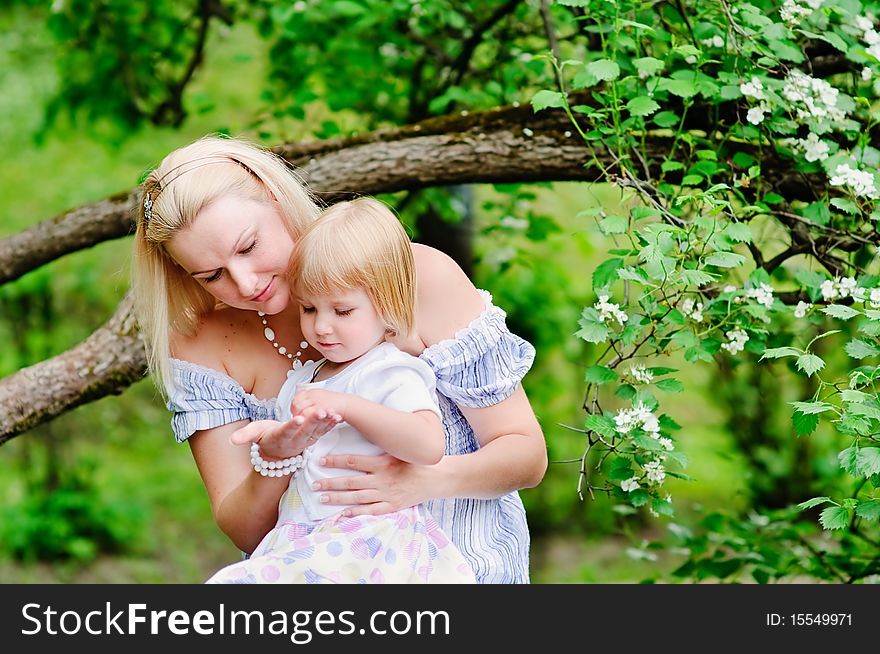 Mother and her daughter in blooming garden