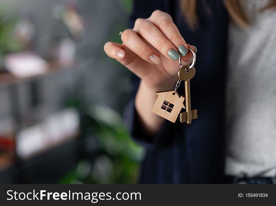 Concept Of Renting An Apartment. House Key In Womans Hands. Young Woman. Modern Light Lobby Interior. Real Estate