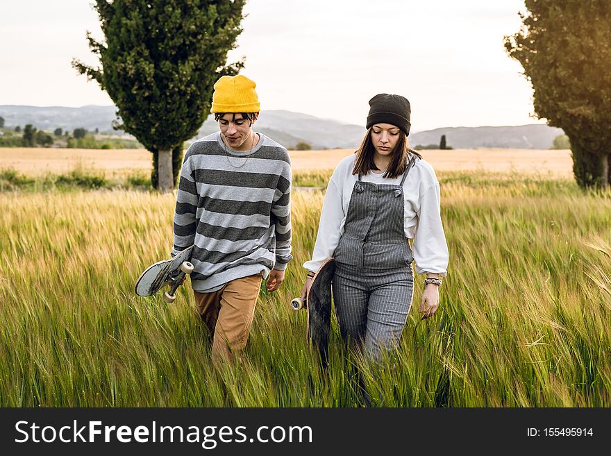 Young couple with casual style riding a skateboard. Millennial young lifestyle