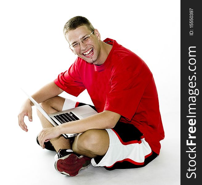 Young man sitting with laptop, laughing