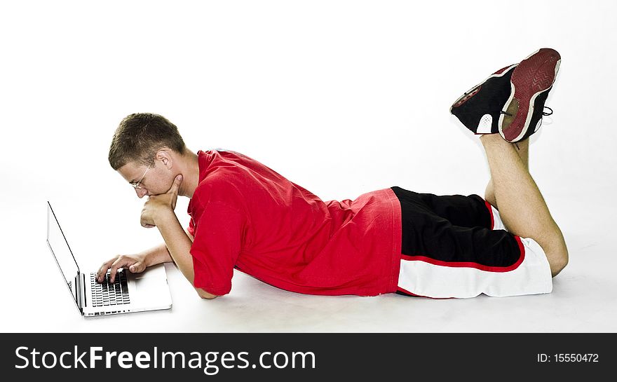 Young Man Lying On Floor And Working On Laptop