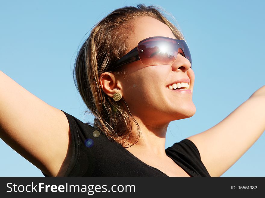 Woman looking at sun with lenses, hand outstretched over blue sky background. Woman looking at sun with lenses, hand outstretched over blue sky background