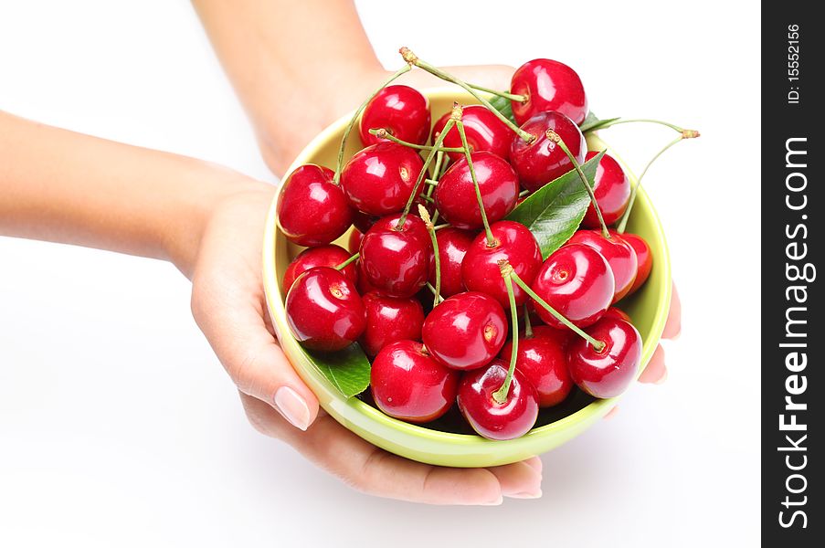 Crockery with cherries in woman hands. Isolated on a white background.