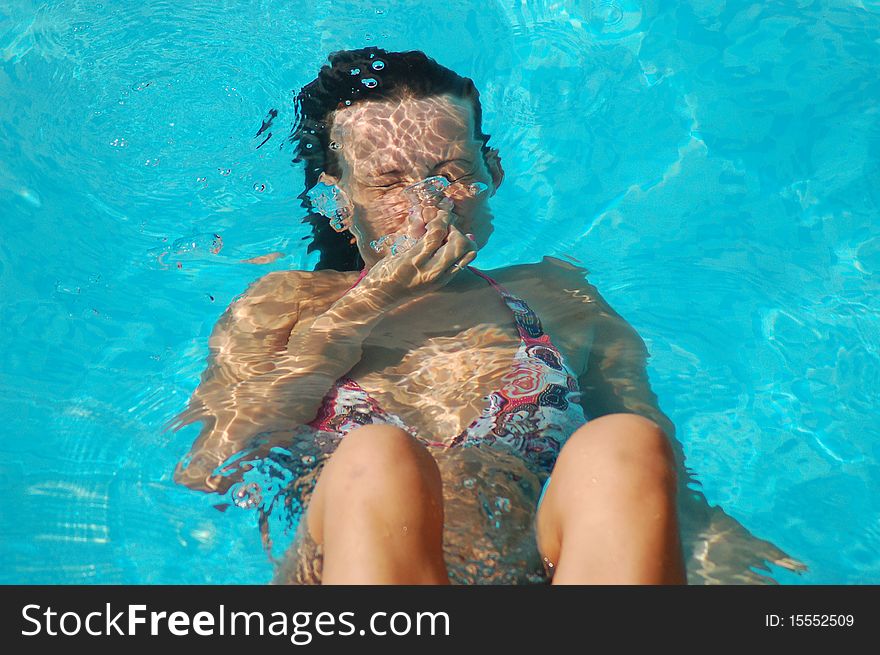 A young girl is diving in a swimming pool